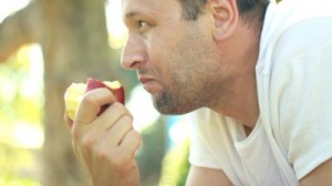 stock-footage-young-man-eating-fresh-apple-outdoor