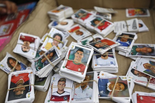 Stickers from the official 2014 FIFA World Cup sticker album are grouped to be exchanged between collectors along a street in Lima