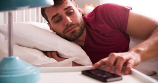 man-in-bed-woken-by-alarm-on-mobile-phone-640x337